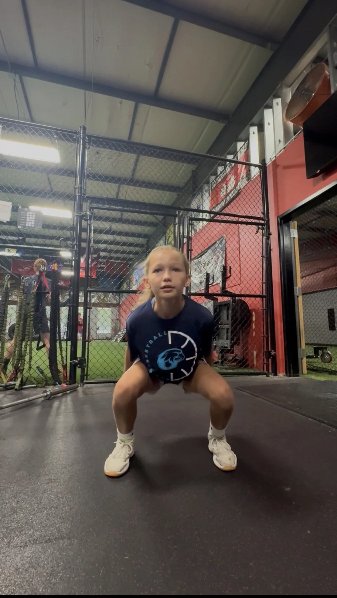 A young basketball player absorbing a landing with her knees tracking over her toes